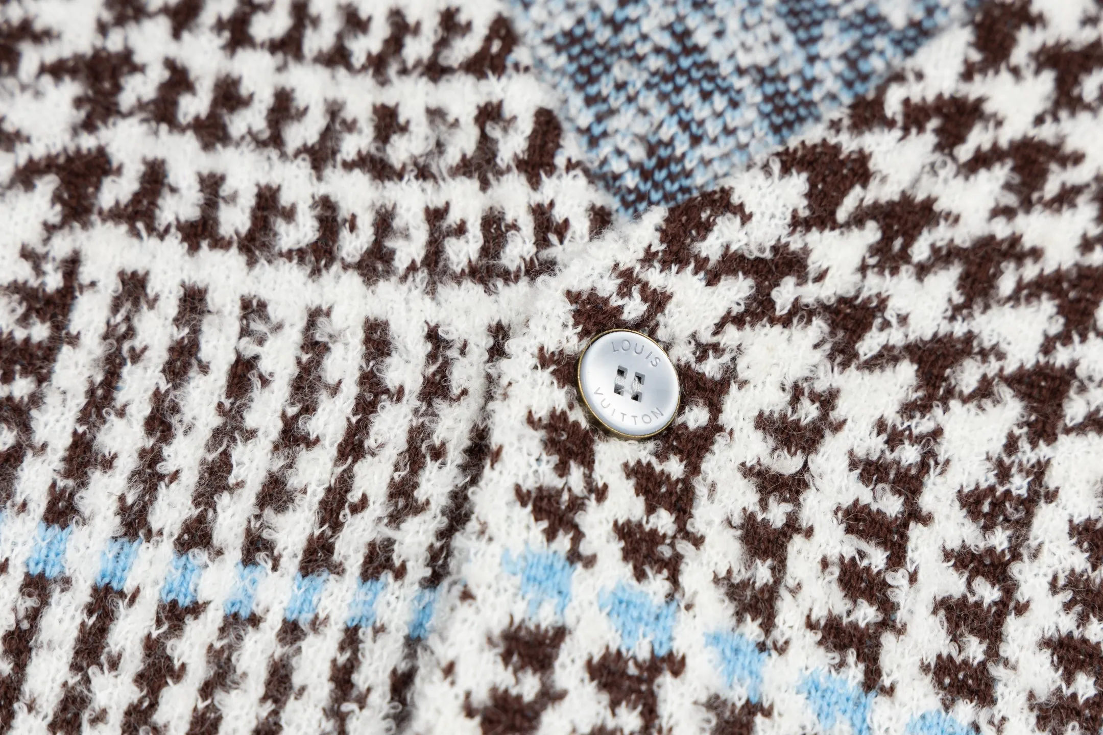 🅿️570 1v 26SS houndstooth letter intarsia V-neck knitted cardigan. The original version was purchased for 14,743 and developed. The fabric is made of yarn fabric made of 69% sheep wool blended with 31% nylon. The main pattern is woven with a full-width jacquard process, which interweaves the houndstooth pattern with light blue line texture. At the same time, the brand logo elements are integrated into the body through the intarsia process, and the edges of the pattern are connected delicately and seamlessly. The collar, cuffs and hem are made of 100% sheep wool ribbed fabric, and are edged with double-needle seaming technology, which has both elasticity and shaping effect. The front placket is equipped with natural-textured buttons, and the side seam pockets use invisible stitching technology to blend naturally with the jacquard texture of the body. The overall shape is shaped through three-dimensional tailoring, and the shoulders are stitched with seamless stitching to ensure fit and comfort. The entire piece is finished with handcrafted details in an Italian workshop, showing the craftsmanship precision of high-quality knitted items. The overall wiring is straight and delicate, the fabric is comfortable and soft, and the color is consistent without color difference. It can be matched with the same style to create a fashionable look and control various occasions. Customized accessories, complete with three standards, the same style for men and women. Size:S-M-L-XL